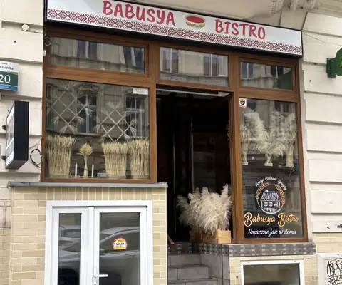 Kamienica z czerwonym szyldem Babusya Bistro nad wejściem